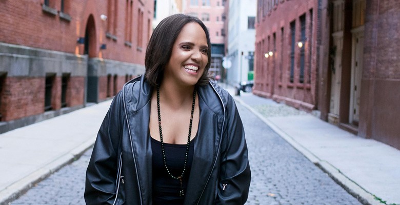 Photo of Terri Lynn Carrington standing on an empty city street and laughing