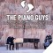 The Piano Guys sitting with a grand piano and cello in front of a rock wall