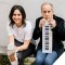 A photo of Larry Golding sitting with a small keyboard on the right and dancer Melinda Sullivan holding a foot up to the camera on the left