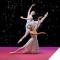 Photo of two ballet dancers on stage in front of a starry backdrop of The Nutcracker